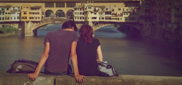 pareja sentada junto a un puente