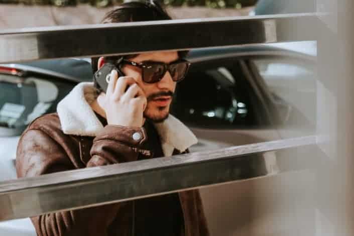 Hombre con gafas de sol mientras usa su teléfono celular