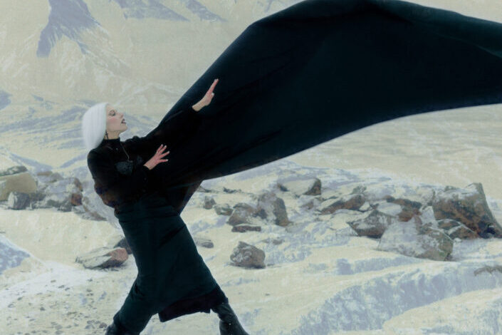 una foto única de una mujer de cabello plateado en una montaña nevada